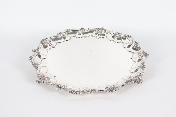 Antico salver inglese in argento Epoca Giorgio IV, con bordo sagomato e cesellato a motivi di volute e conchiglie, sorretto da tre piedini leonini. Bolli Londra 1826, gr. 700