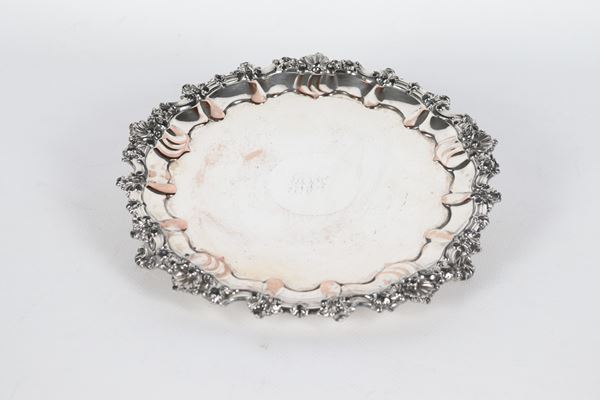 Antique small English salver in Sheffield, with chiselled and embossed edge with scrolls and shells, supported by three curved feet