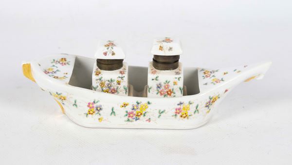 Calamaio in porcellana a forma di giunca, con decorazioni policrome di smalti a rilievo a motivi di fiori, due flaconi di cui uno con rottura al coperchio