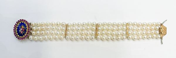 Bracciale di perle a quattro fili, chiusura in oro giallo 18kt con ovale in smalto policromo a motivi floreali contornato da piccoli rubini