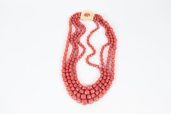 Collana in corallo rosso mediterraneo a quattro fili, con barilotti sfaccettati a gradazione e chiusura in oro giallo 14kt con corallo centrale. Manifattura Inizio XX Secolo, gr. 210