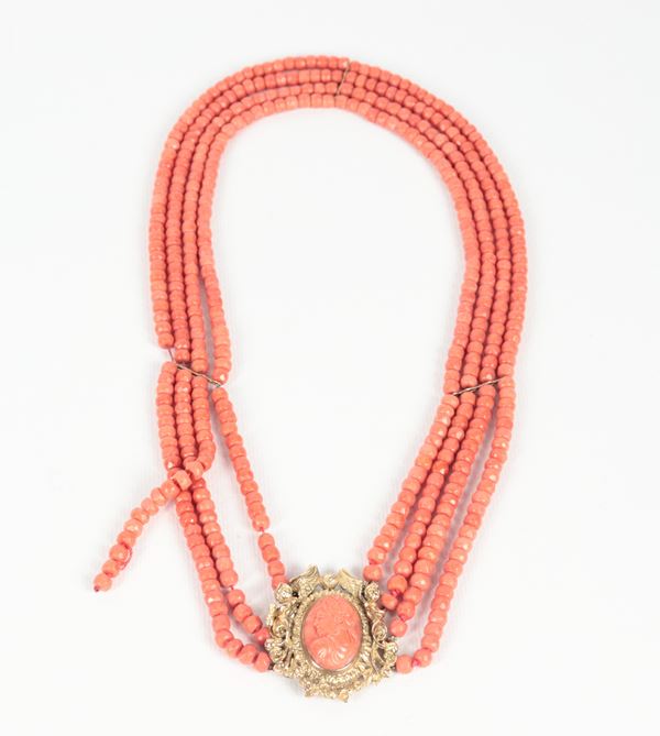 Four-strand red-orange Mediterranean coral necklace, with faceted barrels and 12kt yellow gold clasp with coral cameo. One strand needs to be rethreaded. Early 20th century manufacture, 130g