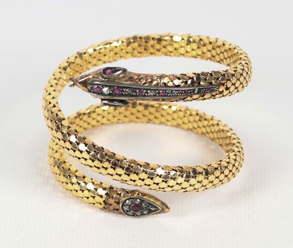 Bracciale a serpente in oro giallo 18kt, sulla testa e sulla coda piccoli diamanti e rubini incastonati in argento. Manifattura Inizio XX Secolo, gr. 68,7