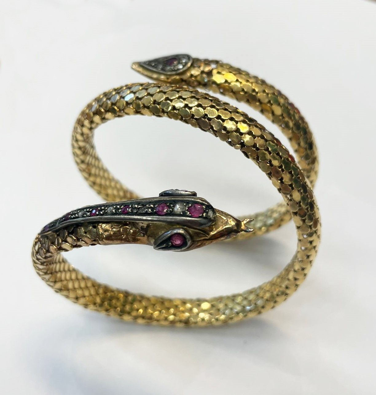 Bracciale a serpente in oro giallo 18kt, sulla testa e sulla coda piccoli diamanti e rubini incas...