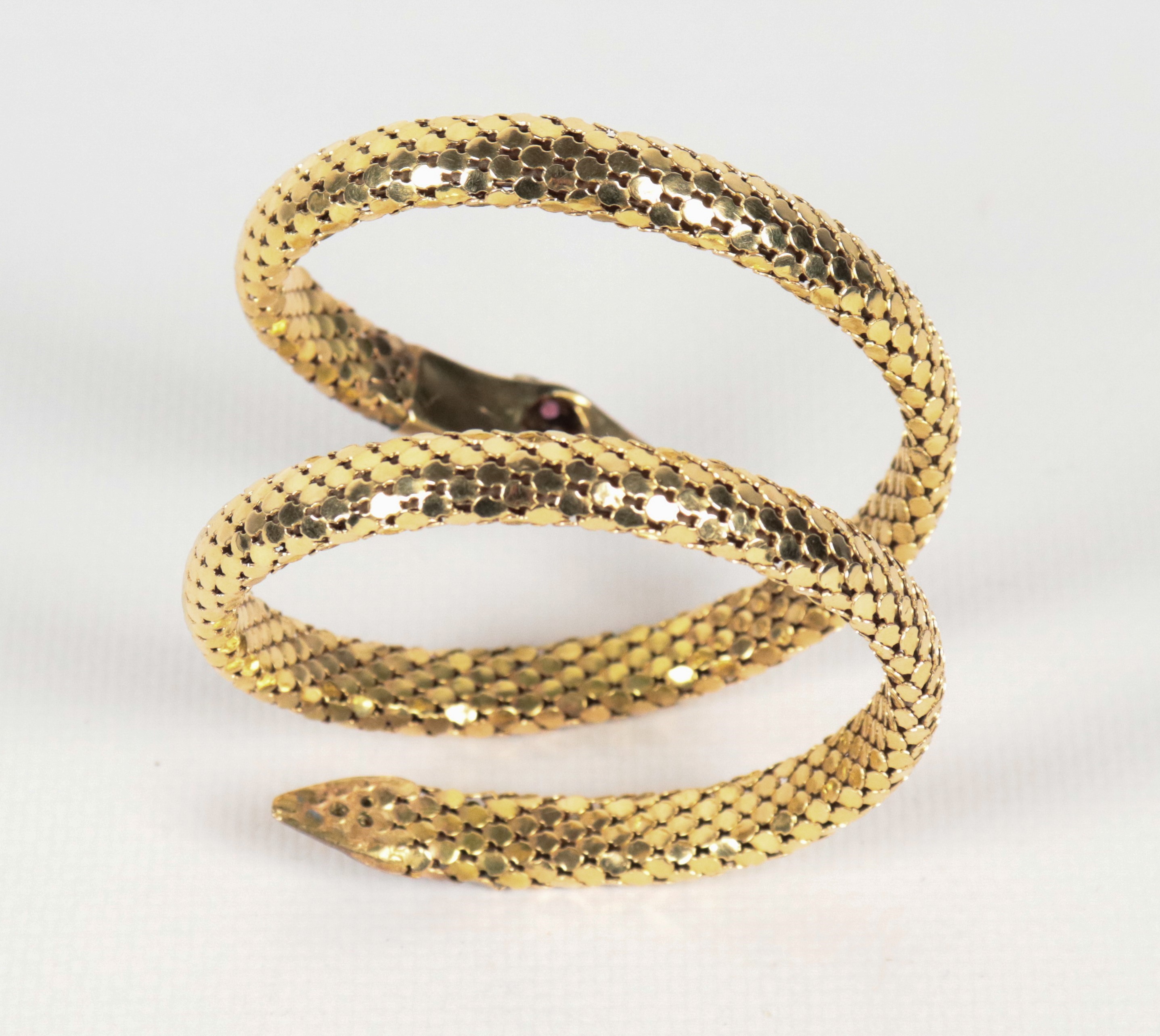 Bracciale a serpente in oro giallo 18kt, sulla testa e sulla coda piccoli diamanti e rubini incas...