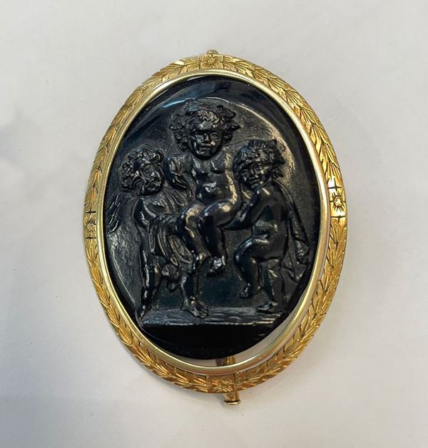 Brooch with black glass paste cameo mounted in 18kt yellow gold