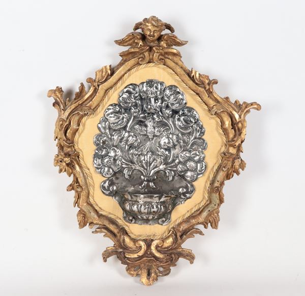 Antique holy water stoup in chiseled and embossed silver, in an antique gilded and carved wooden frame