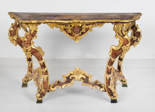 Antique console table in gilded and lacquered wood, entirely carved in relief with Louis XV motifs of floral scrolls and central mask