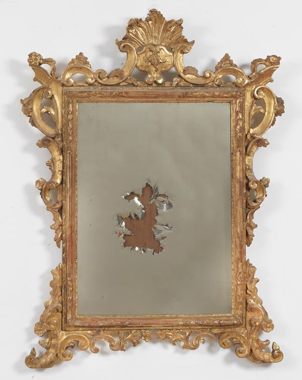 Antique mirror in gilded wood and richly carved with Louis XV motifs, the mercury of the mirror is damaged