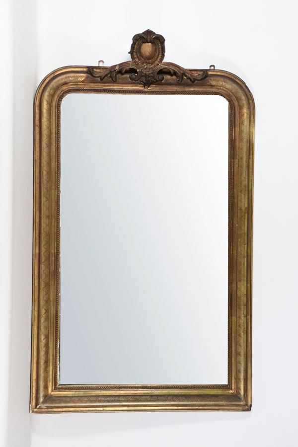 Antique Neapolitan Louis Philippe mirror, in gilded and carved wood with a small worked top. The top has defects