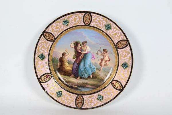 Antique Vienna porcelain plate, entirely decorated and painted with a central medallion depicting &quot;The Revenge of Love&quot;, edge decorated with floral scroll motifs in relief in gold. Late 18th century. The plate has cracks