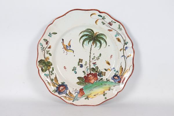 Antico piatto in maiolica Milano interamente decorato a rilievo a volute floreai, palma e pappagallo