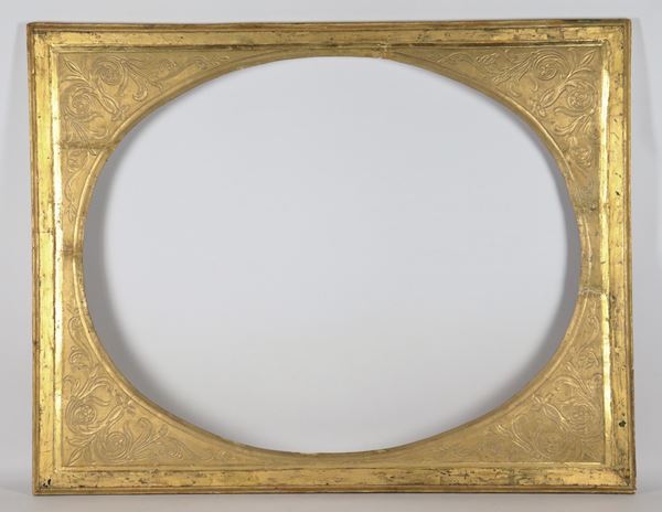 Antique oval frame in gilded wood, carved and sgraffito