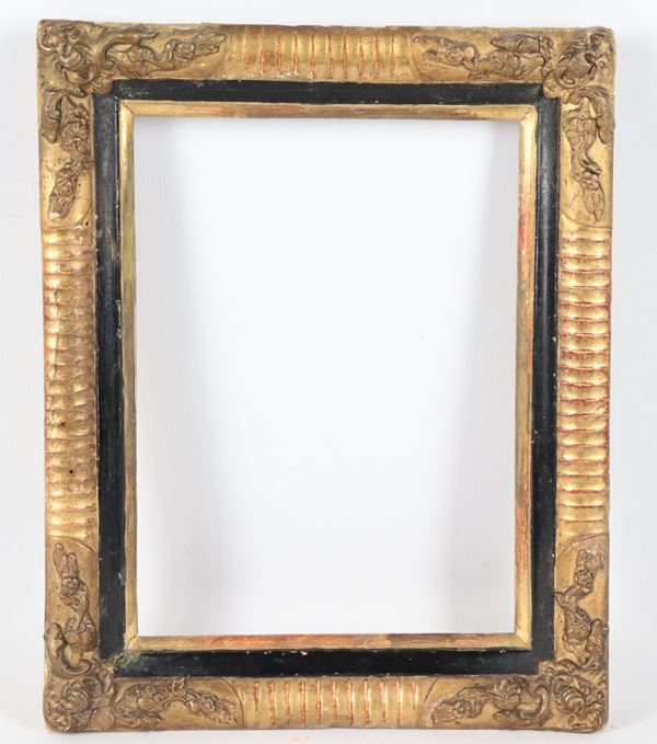 Antique small frame in gilded, carved and ebonized wood