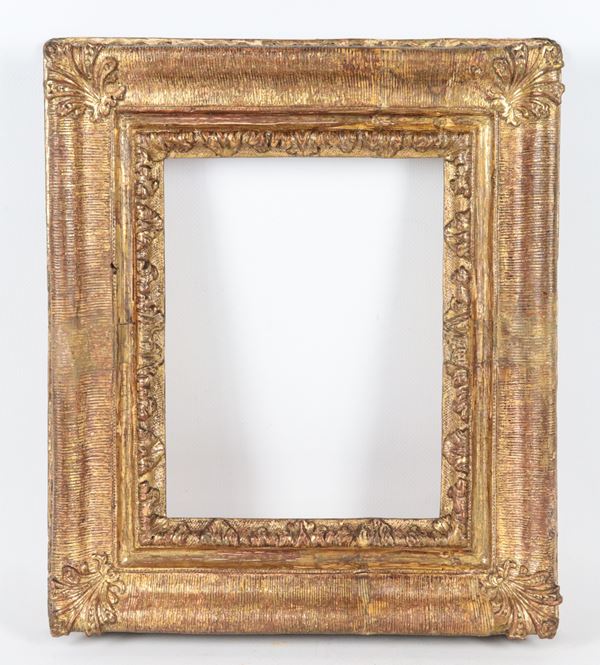 Antique small frame in gilded wood and carved with palmettes