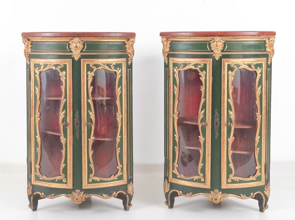 Pair of antique corner cabinets from the Marche region in the Louis XV style, in gilded wood and green and red lacquer with vegetal scroll carvings, two glass doors and curved legs